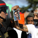A Black Lives Matter protester holds a photo of Stephon Clark in front of a California Highway Patrol officer as they block an entrance to Interstate 5 during a demonstration March 23, 2018, in Sacramento, Calif.